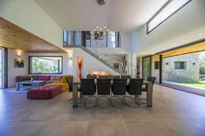 a dining room and living room with a table and chairs at Villa 18 in Porto-Vecchio