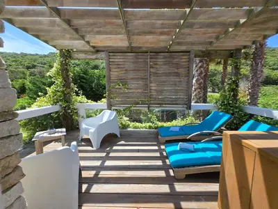 a patio with blue chairs and a table at Villa Petra Bianca Suites & Chambres in Bonifacio