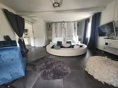 a living room with a white couch and a tv at Villa Petra Bianca Suites & Chambres in Bonifacio
