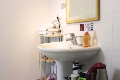 a bathroom with a sink and a mirror and towels at Villa Ghiatone in Pietrosella