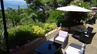 a patio with a table and chairs and an umbrella at Villa Ghiatone in Pietrosella