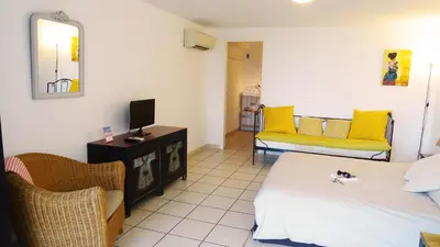 a room with two beds and a tv and chairs at Villa Ghiatone in Pietrosella