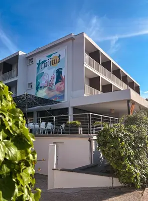 a building with a sign on the side of it at Hotel l'Isolella in Porticcio