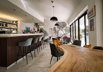 a bar with a wooden table and chairs at Hotel l'Isolella in Porticcio