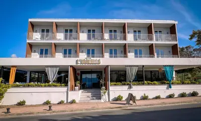 a large white building on the side of the street at Hotel l'Isolella in Porticcio
