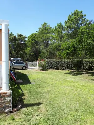 a yard with a white column and a house at Mini Villa à 100m de la mer avec prise de recharge élec privative in Sari Solenzara
