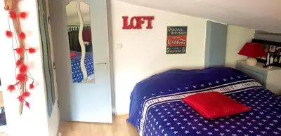 a bedroom with a blue bed with a red pillow at Maison du bonheur in Borgo