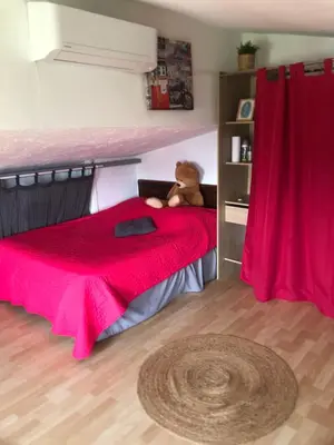 a teddy bear sitting on a bed in a bedroom at Maison du bonheur in Borgo
