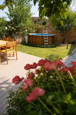 a backyard with a pool and a table and flowers at Pianotolu - Rez de villa entre mer et montagne in Moltifao
