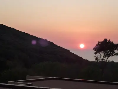 a sunset from the balcony of a house at Résidence de Tourisme Mare e Macchia in Tizzano