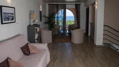 a living room with a couch and a view of the ocean at Orizonte in Cervione