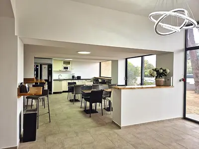 a kitchen and dining room with tables and chairs at Hôtel le Colibri in Lucciana
