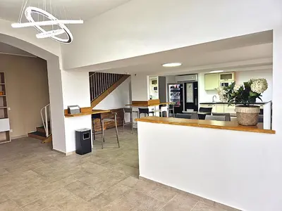a lobby with a bar with chairs and tables at Hôtel le Colibri in Lucciana