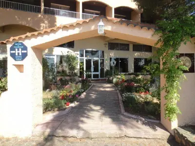 a building with a walkway in front of it at Hôtel le Colibri in Lucciana