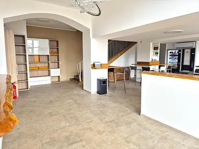a living room with a tile floor and a counter at Hôtel le Colibri in Lucciana