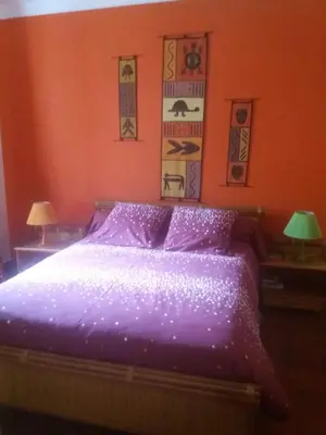 a bedroom with a purple bed with two lamps at Villa Savane in Ajaccio