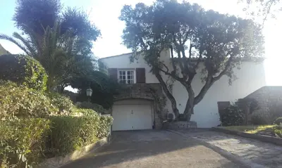 a white house with a tree and a garage at Villa Savane in Ajaccio