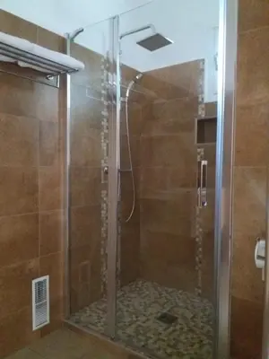 a shower with a glass door in a bathroom at Villa Savane in Ajaccio