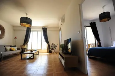 a living room with a bed and a television at T2 Terrasse Vue Mer - Route des Sanguinaires in Ajaccio