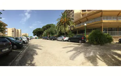 a parking lot with cars parked next to a building at T2 Terrasse Vue Mer - Route des Sanguinaires in Ajaccio