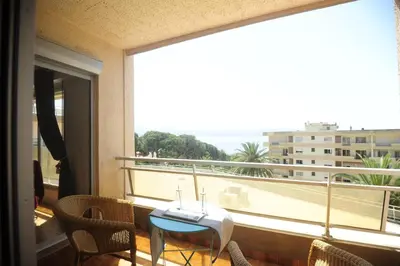 a balcony with a table and chairs and a large window at T2 Terrasse Vue Mer - Route des Sanguinaires in Ajaccio