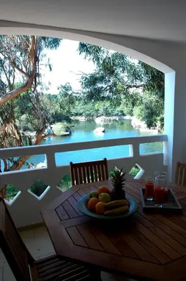 a plate of fruit on a table with a view of a river at Cala di Sole Lecci in Porto-Vecchio