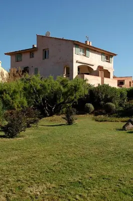 a large house with a yard in front of it at Cala di Sole Lecci in Porto-Vecchio