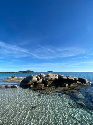 a group of rocks in the water on a beach at Cala di Sole Lecci in Porto-Vecchio