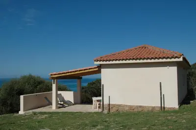 a small white building with a table and chairs at Residence Capicciolo in Olmeto