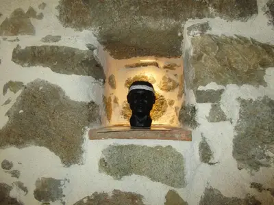 a statue of a face in a hole in a wall at Chez Marco Gîte & SPA CAPPELLINA in Muro