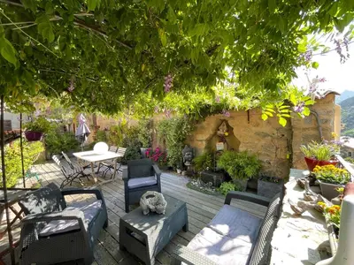 a patio with chairs and a table and a tree at Chez Marco Gîte & SPA CAPPELLINA in Muro