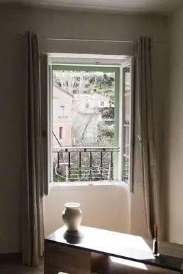 a vase sitting on a table in front of a window at Charmant F2 dans joli village Corse in Omessa