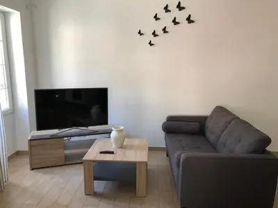 a living room with a couch and birds on the wall at Charmant F2 dans joli village Corse in Omessa