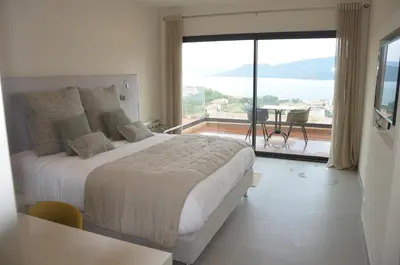 a bedroom with a large bed and a large window at Casa Mare E Vista in Propriano