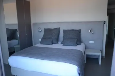 a bedroom with a large bed with blue sheets and pillows at Casa Mare E Vista in Propriano