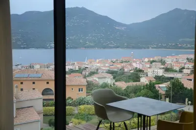 a table and a chair in front of a window at Casa Mare E Vista in Propriano