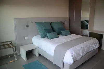 a bedroom with a large white bed with blue pillows at Casa Mare E Vista in Propriano