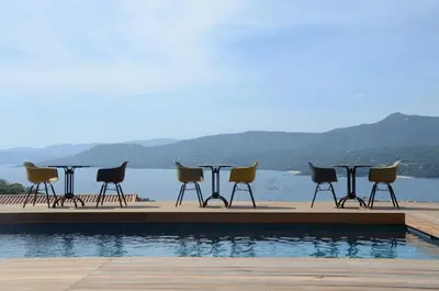 a table and chairs sitting next to a pool at Casa Mare E Vista in Propriano