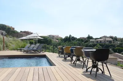 a deck with chairs and a table and a pool at Casa Mare E Vista in Propriano
