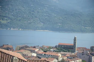a town with a clock tower and a body of water at Casa Mare E Vista in Propriano
