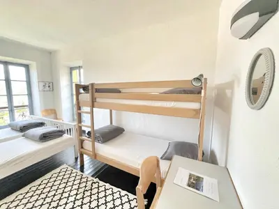 a room with two bunk beds and a table at Gîte du Chalet Pietri in Olivese