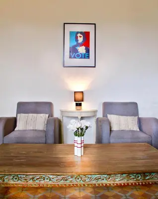 a room with a table with a lamp and two chairs at Gîte du Chalet Pietri in Olivese