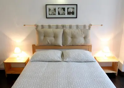 a bedroom with a bed with pillows and two lamps at Gîte du Chalet Pietri in Olivese
