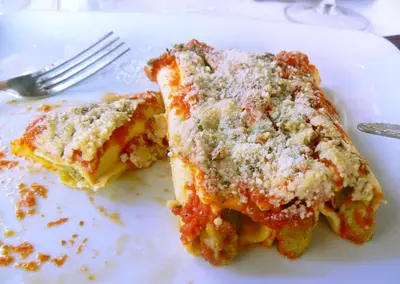 a slice of pizza on a plate with a fork at Gîte du Chalet Pietri in Olivese