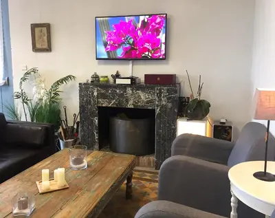 a living room with a fireplace with a tv above it at Gîte du Chalet Pietri in Olivese