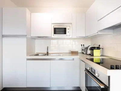 a white kitchen with a sink and a microwave at Apartment Résidence Cita di Sali-7 by Interhome in Porto-Vecchio
