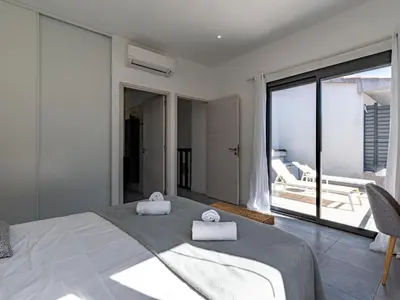 a bedroom with a large bed with two towels on it at Holiday Home St Cyprien Plage by Interhome in San Ciprianu
