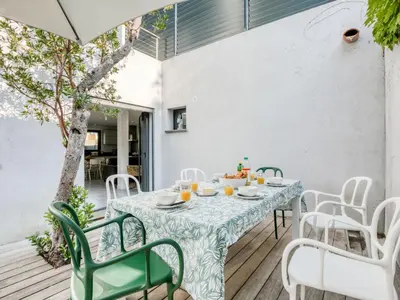 a table and chairs on a wooden deck with a table and chairs at Holiday Home St Cyprien Plage by Interhome in San Ciprianu