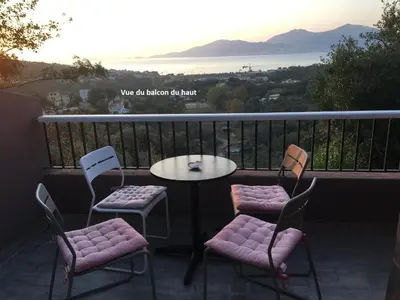 a table and chairs on a balcony with a view of the ocean at Villa La Viva Porticcio in Porticcio