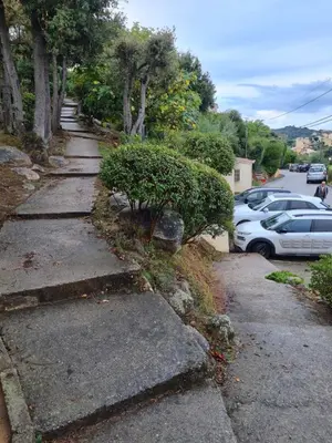 a sidewalk next to a parking lot with cars at Villa La Viva Porticcio in Porticcio